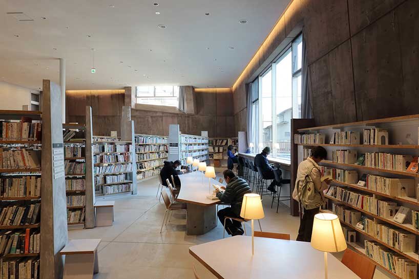 monolithic library extension by maru architecture floats on serene pond in matsubara, japan