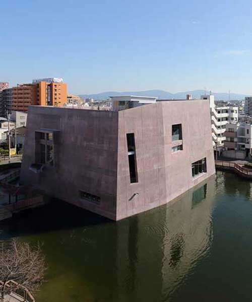 monolithic library extension by maru architecture floats on serene pond in matsubara, japan