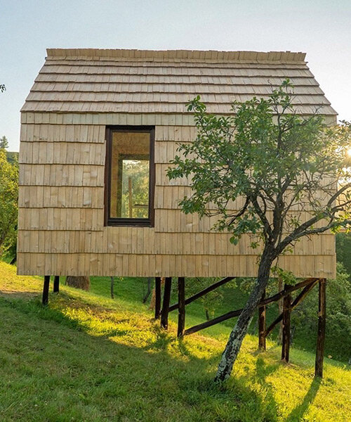 wood + shingle tiny hut built by romanian volunteers encourages locals to immerse in nature