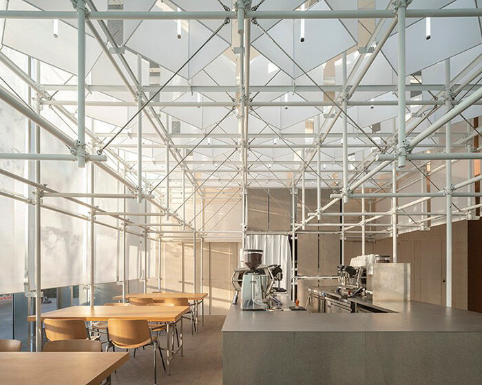 scaffolding + translucent skin form coffee shop pavilion within office building in shanghai