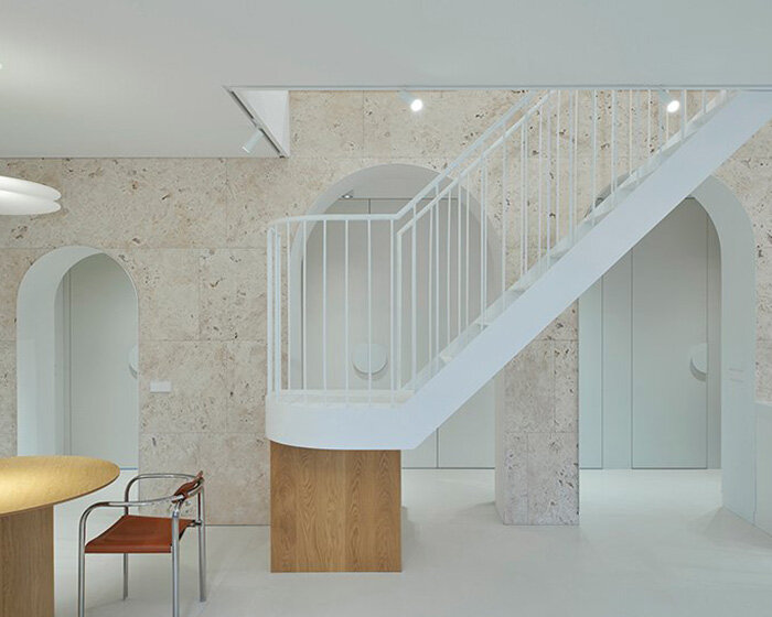 travertine wall punctured by arches forms 'greetings from rome !' residence in lithuania