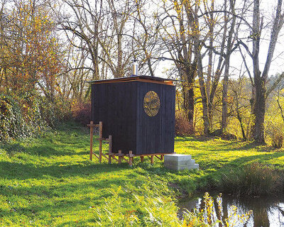 this charred timber sauna by atelier AJO emerges on the shore of french lake