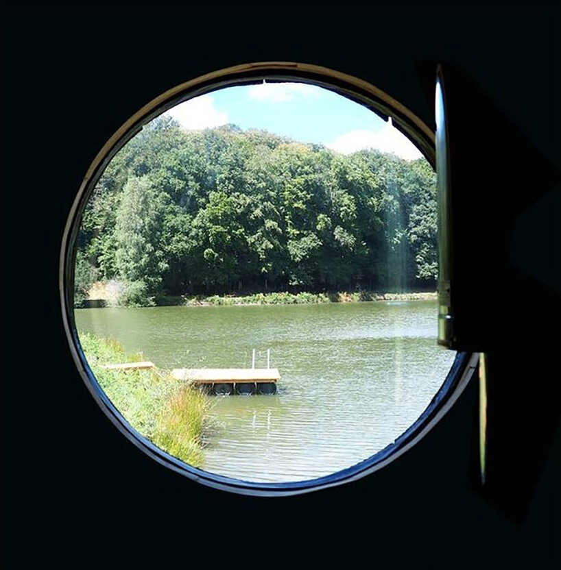 this charred timber sauna by atelier AJO emerges on the shore of french lake