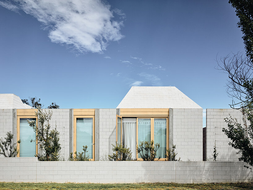 concrete masonry blocks + frustum roofs animate the façade of this beach house by architects EAT