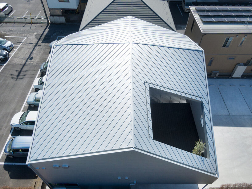 roof cut out reveals secluded terrace in this mixed-use building in japan