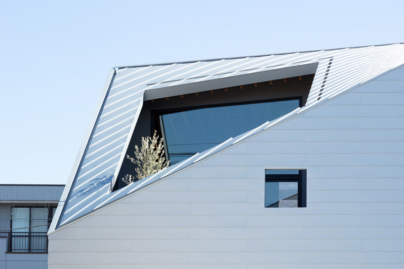 roof cut out reveals secluded terrace in this mixed-use building in japan