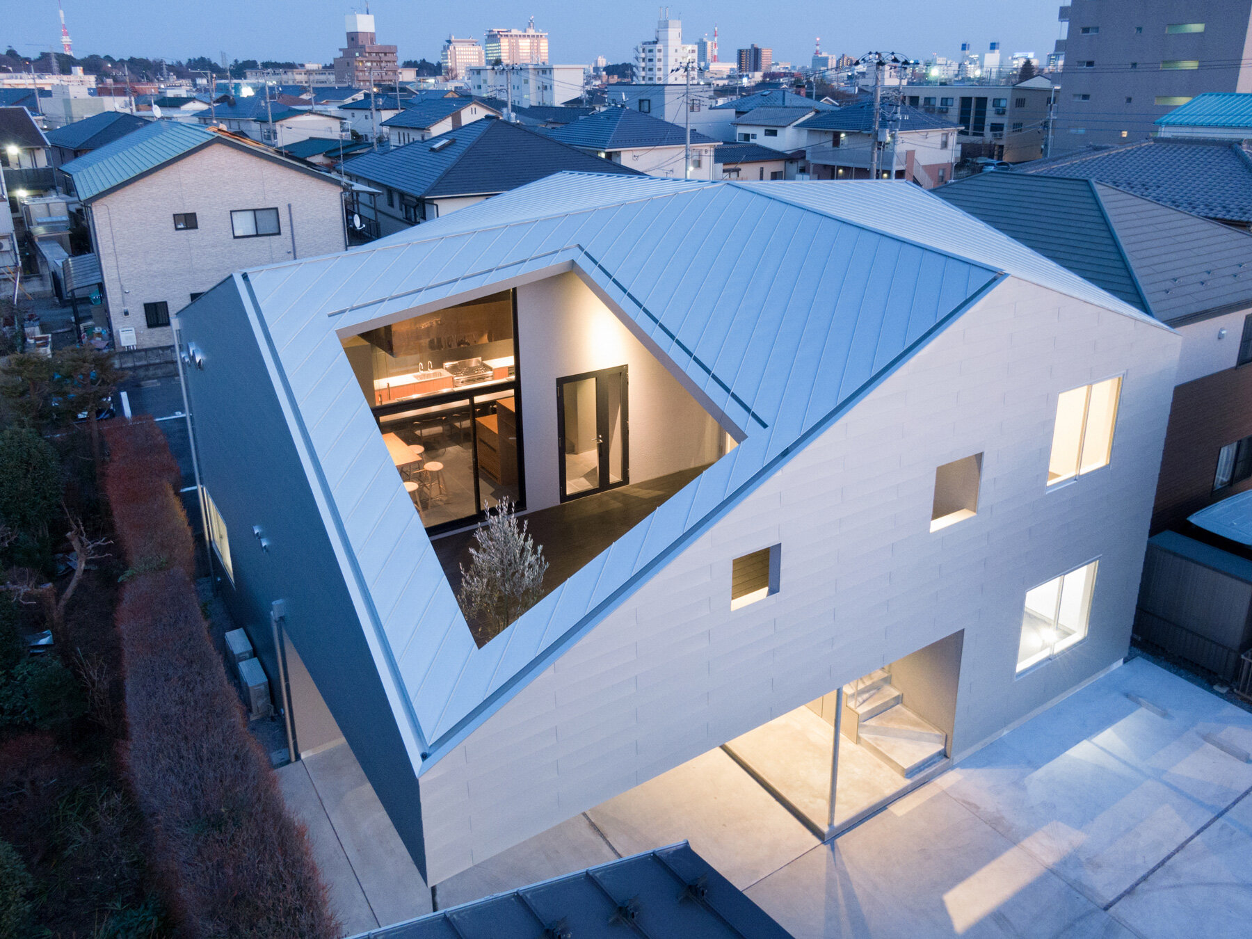 roof cut out reveals secluded terrace in this mixed-use building in japan