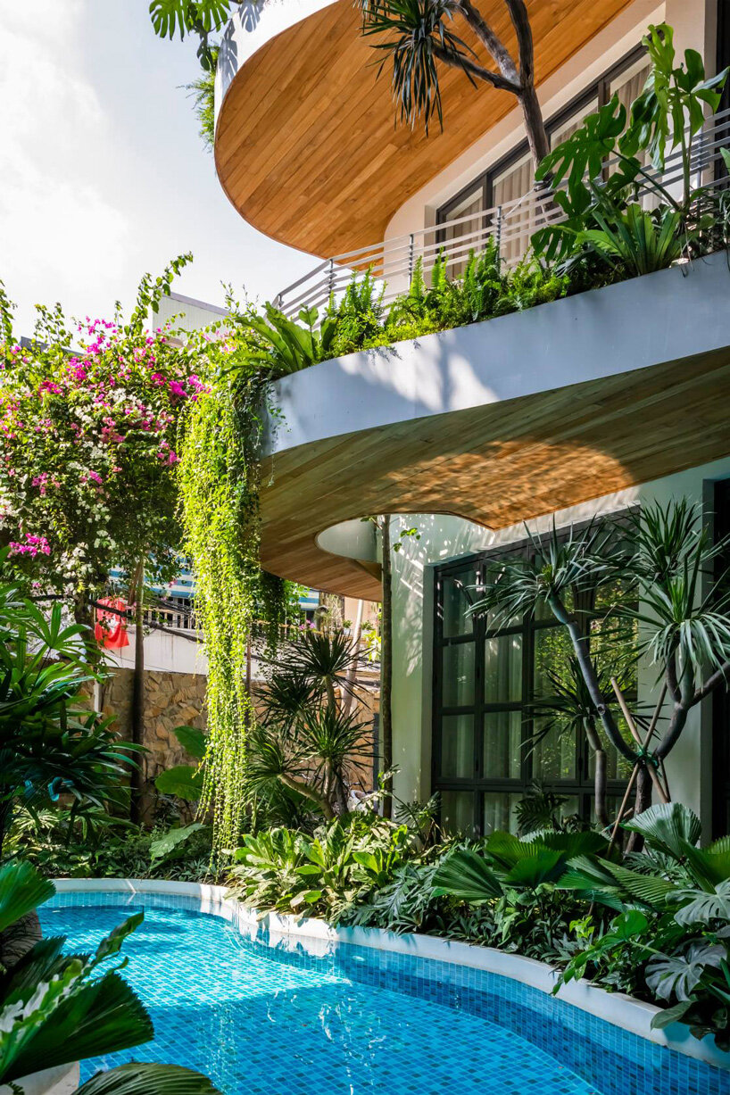 plants cascade from the undulating balconies of this vietnam apartment ...