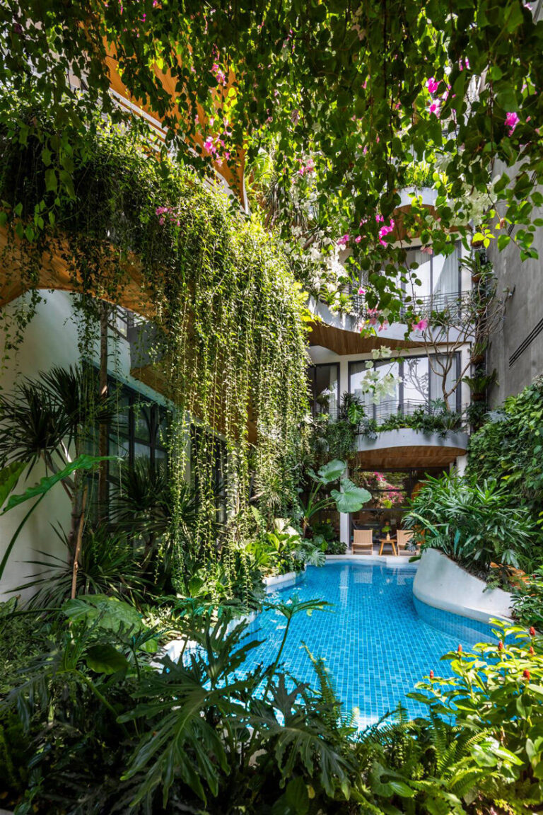 plants cascade from the undulating balconies of this vietnam apartment