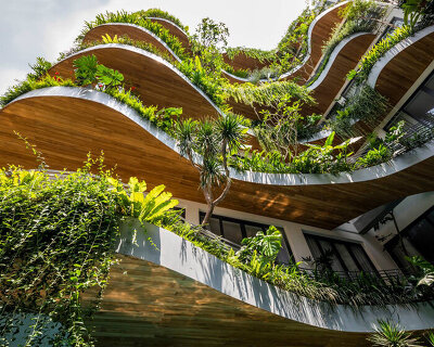 tropical plants cascade from the undulating balconies of this apartment building in vietnam