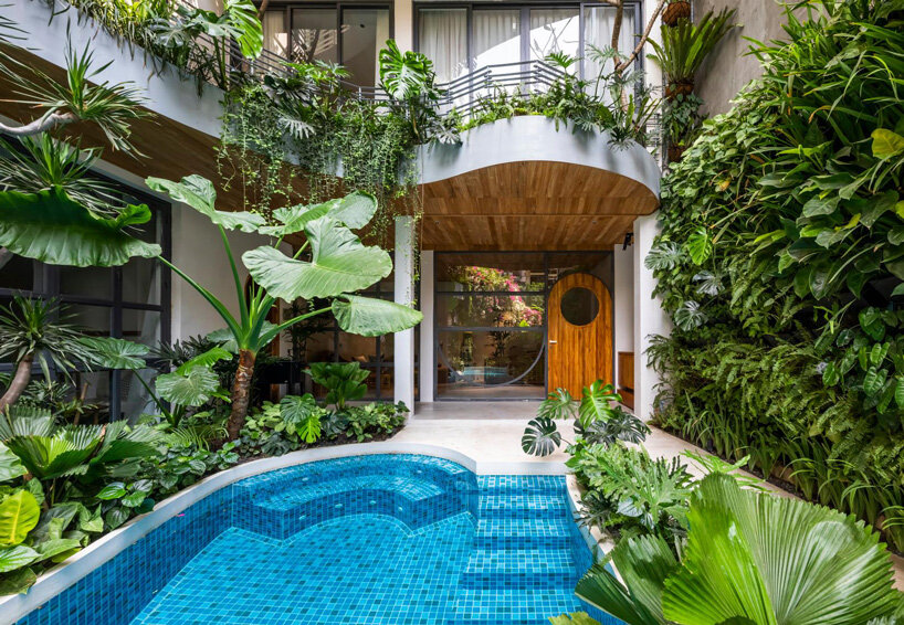 tropical plants cascade from the undulating balconies of this apartment building in vietnam