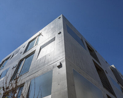 concrete box residence by ryuichi sasaki reflects its surroundings in tokyo