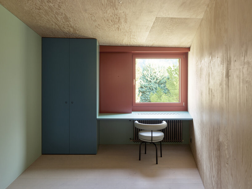 an angular timber house is planned around an old tree in bex, switzerland