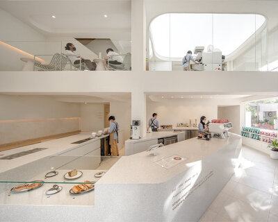 warm neutrals and soft curves shape PAGA microroastery in bangkok