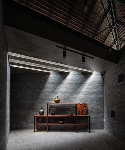solemn shadowplay + exposed roofing highlight lacquerware pieces in vietnamese showroom