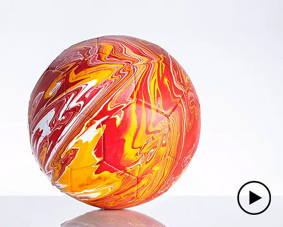 fusion paint-pouring turns national football strips into colorful marbled balls 