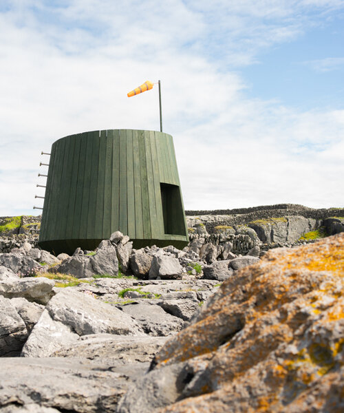 green stained timber and salvaged trawler nets build an artist's cabin in ireland