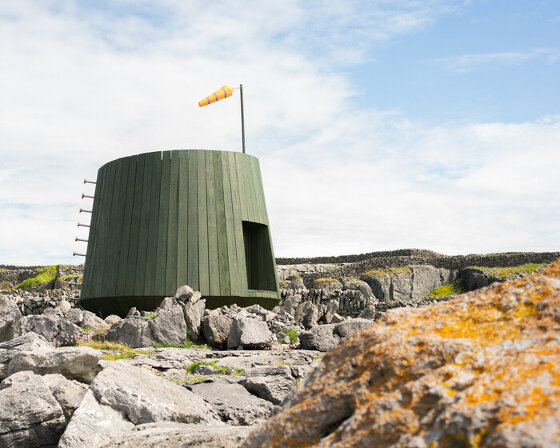 green stained timber and salvaged trawler nets build an artist's cabin in ireland