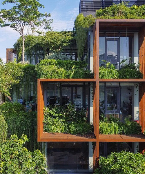 a blanket of greenery envelops TAA design's stacked office building in vietnam