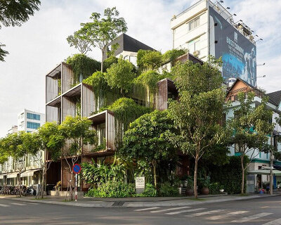 a blanket of greenery envelops TAA design's stacked office building in vietnam