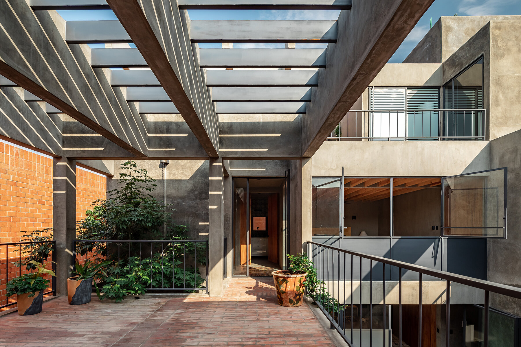 well-lit patio blurs boundaries in espacio 18 arquitectura's house in ...