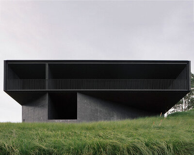 edition office anchors black concrete residence with timber batten shell to australian hilltop