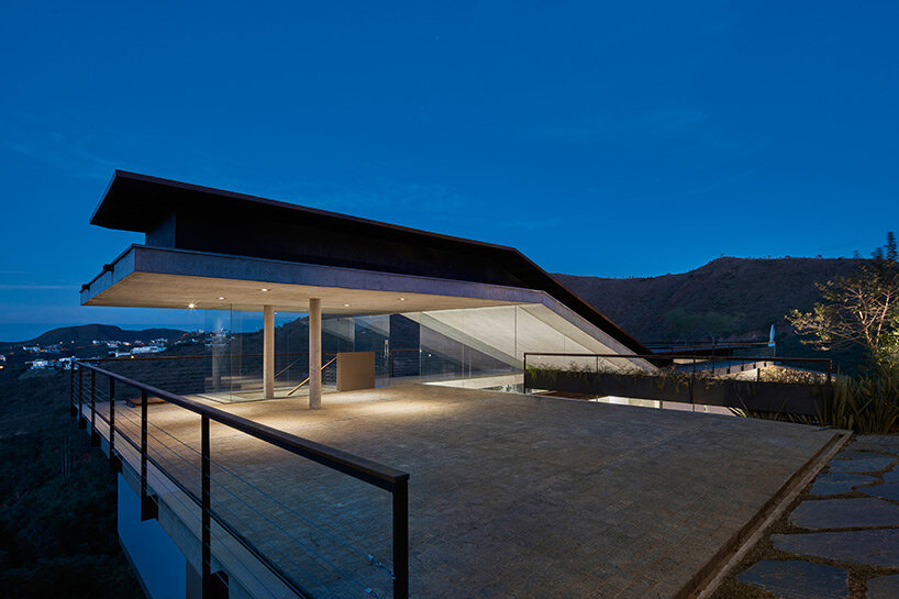 tetro tops residence with irregular deck roof opening towards mountainous views in brazil