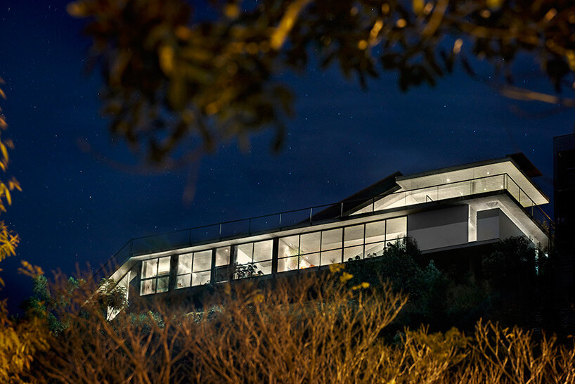 tetro tops residence with irregular deck roof opening towards mountainous views in brazil