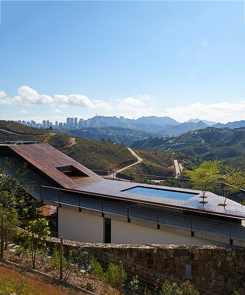 tetro tops residence with irregular deck roof opening towards mountainous views in brazil