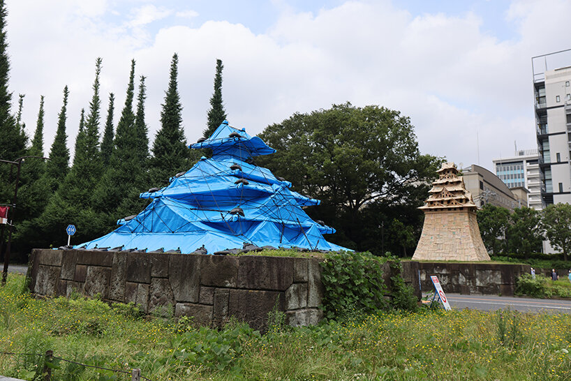 cardboard + blue tarp castle by makoto aida stands out in tokyo to emphasize temporariness