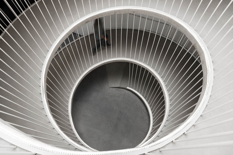 sculptural spiral staircase connects paulo merlini's warehouse turned office in portugal