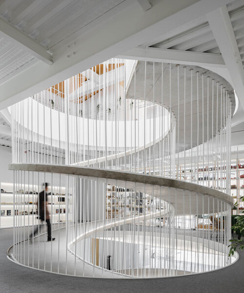 sculptural spiral staircase connects paulo merlini's warehouse turned office in portugal