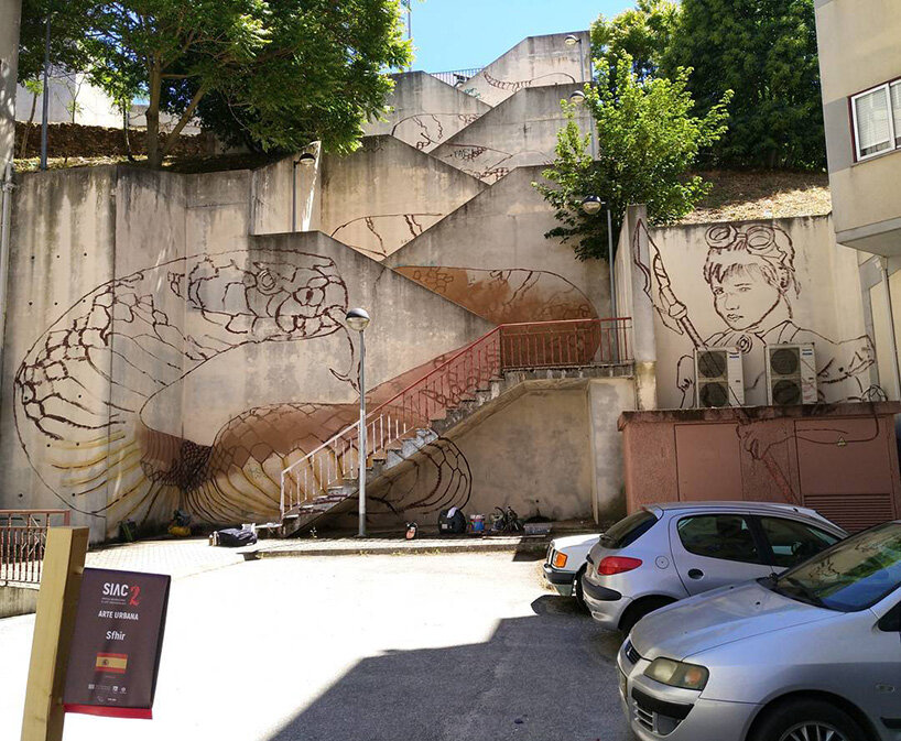 a giant snake moves down a massive staircase in this graffiti by SFHIR in portugal