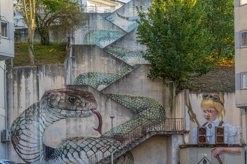 a giant snake moves down a massive staircase in this graffiti by SFHIR in portugal