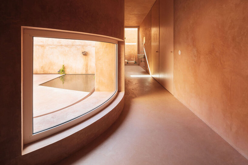 pigmented lime mortar + cork clad this vacation home beside long swimming pool in portugal