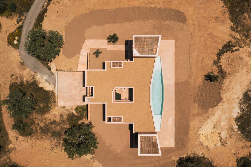 pigmented lime mortar + cork clad this vacation home beside long swimming pool in portugal