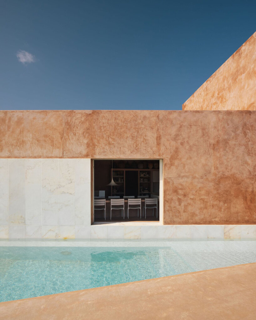 pigmented lime mortar + cork clad this vacation home beside long swimming pool in portugal