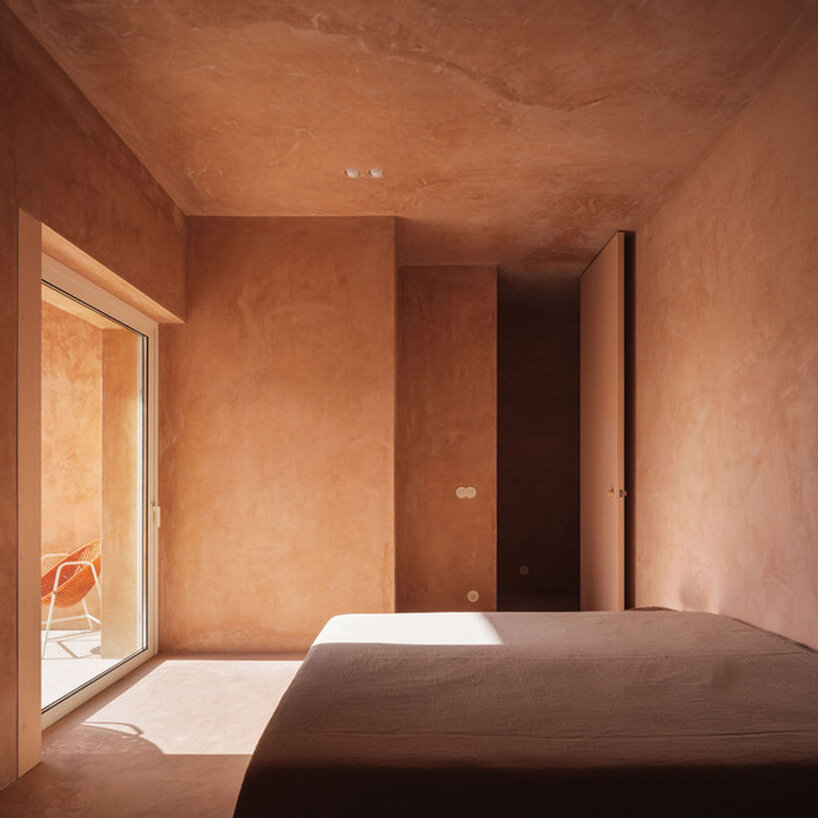 pigmented lime mortar + cork clad this vacation home beside long swimming pool in portugal