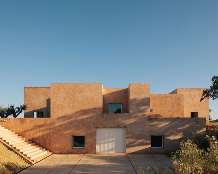 pigmented lime mortar + cork clad this vacation home beside long swimming pool in portugal