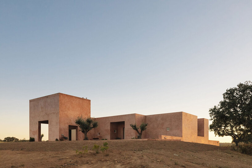 pigmented lime mortar + cork clad this vacation home beside long swimming pool in portugal