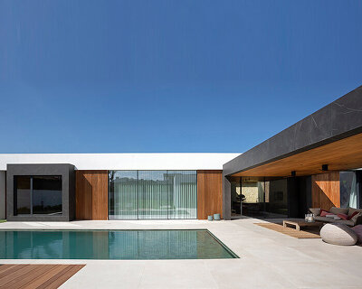 wooden elements + rectangular white volumes characterize the façade of this spacious house in spain