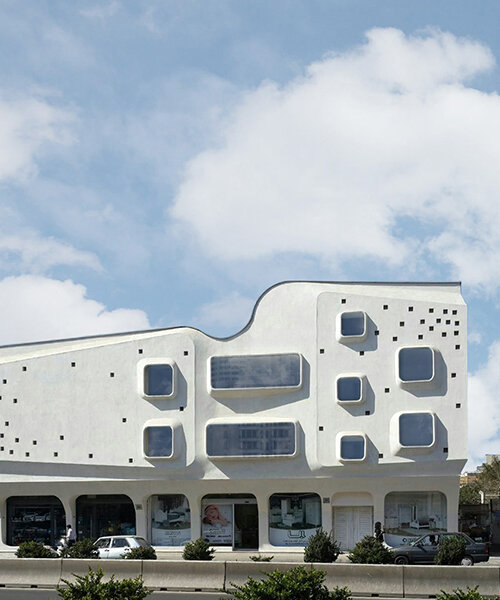 curved angles, extruded window frames + square dots characterize futuristic building in iran