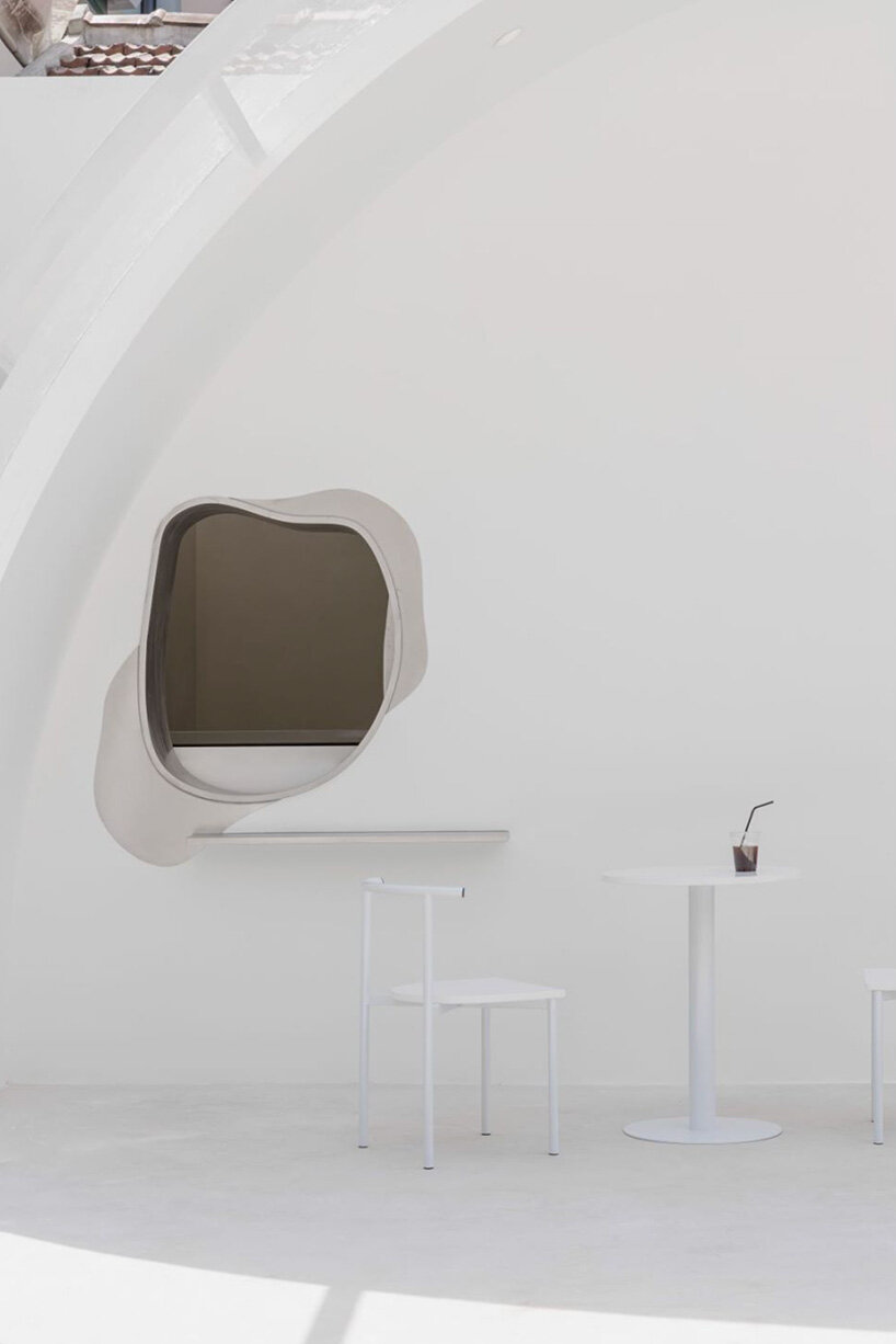 curvilinear display + minimal forms decorate this all-white clothing store in shanghai