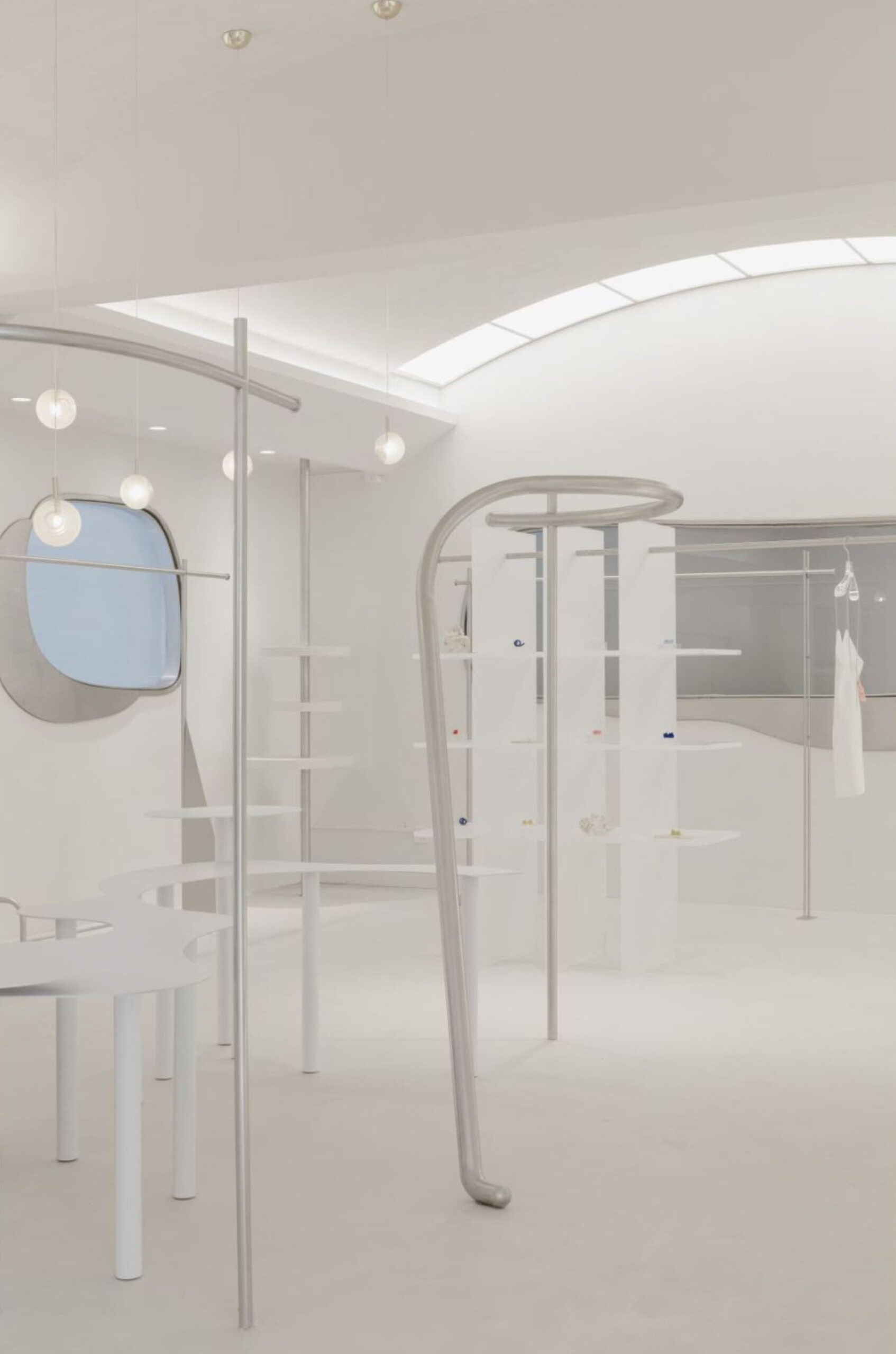 curvilinear display + minimal forms decorate this all-white clothing store in shanghai