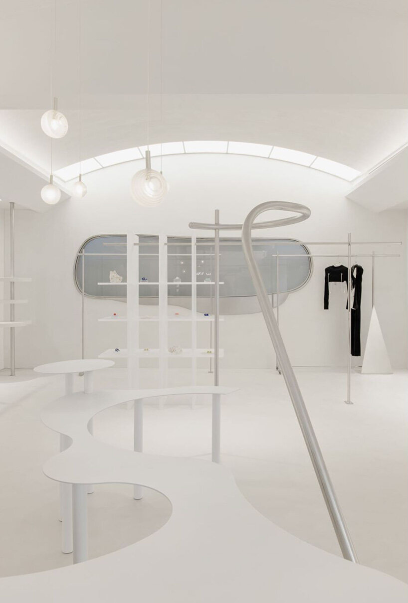 curvilinear display + minimal forms decorate this all-white clothing store in shanghai