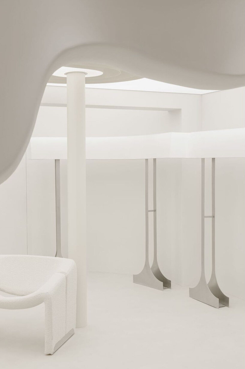 curvilinear display + minimal forms decorate this all-white clothing store in shanghai