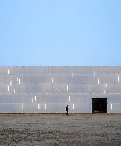 scaffolding wrapped in translucent cloth assembles temporary pavilion on chinese beach