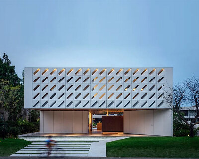 white perforated shading module wraps the façade of this beach house in brazil