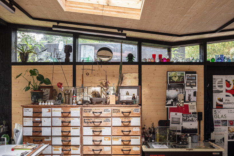 prefabricated artist studio nestles within the verdant backyard of a 60s bungalow in belgium