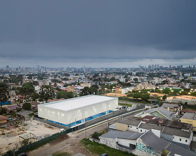 new sports pavilion in brazil takes shape as a suspended box that lights up at night